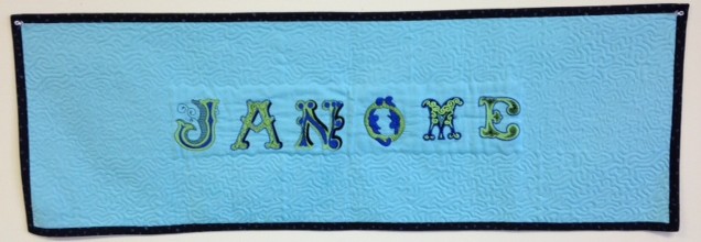 Decided to keep it simple and just have the word JANOME  embroidered surrounded by Acufil stippling. Banner was bound using the JANOME QUILT BINDER SET